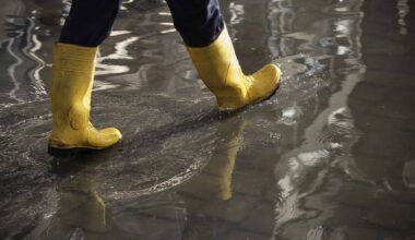 seguro cobre enchente: bota de plástico andando em ambiente alagado